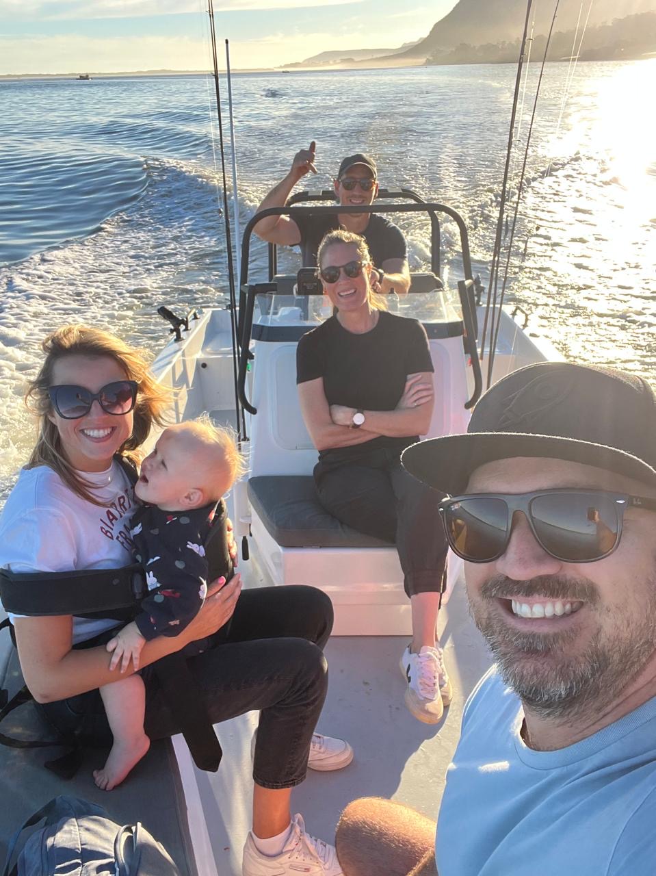 Family smiling on a boat cruising the lagoon in golden afternoon light